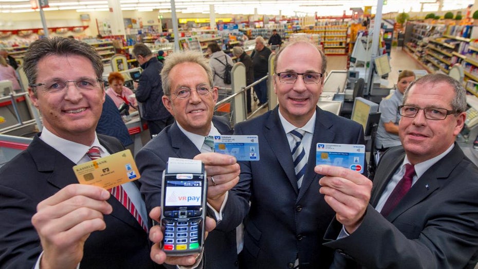 Am Pilotprojekt waren vier örtliche Banken und ein Verbund des Einzelhändlers Edeka beteiligt – von links nach rechts, in einem Edak-Markt in der Pilotregion: Wolfgang Osse, Vorstand der Kasseler Bank, Hans-Richard Schneeweiß, Geschäftsführer der EDEKA Handelsgesellschaft Hessenring, Hans-Christian Reuß, Vorstand der Volksbank Göttingen und Michael Hohmann, Vorstandsvorsitzender der Raiffeisenbank Baunatal. (Foto: bvr)