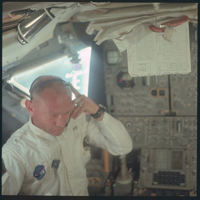 Buzz Aldrin im Inneren der Apollo-11-Raumfähre. Im Hintergrund ist rechts unten das DSKY-Bedienpanel des Apollo Guidance Computers zu erkennen. (Quelle: NASA)