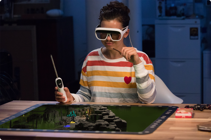 Spieler mit Wand-Controller und AR-Brille vor Tilt-Five-Spielbrett.