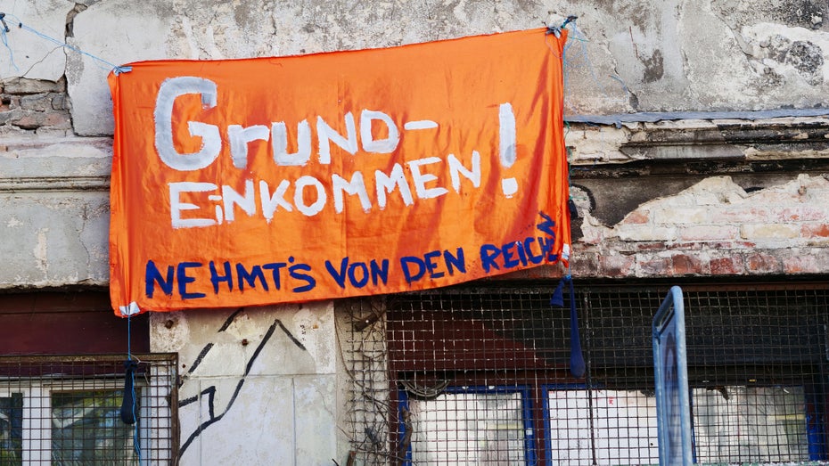 Plakat für bedingungsloses Grundeinkommen (BGE) in Berlin. (Foto: dpa) Bedingungsloses Grundeinkommen: Finnland erklärt Experiment für vorerst gescheitert