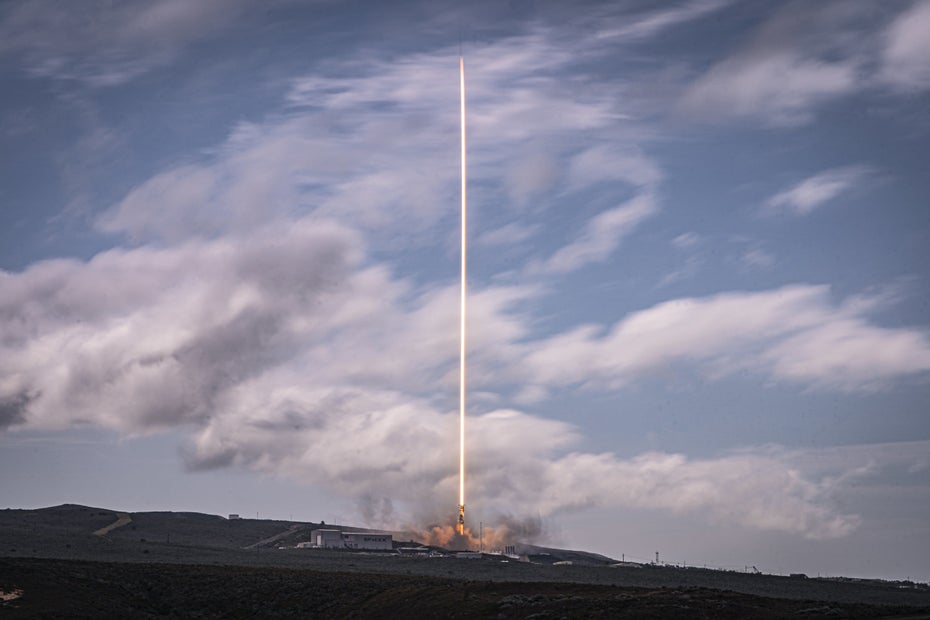 Eine Rakete startet von der Erde Richtung Weltraum.