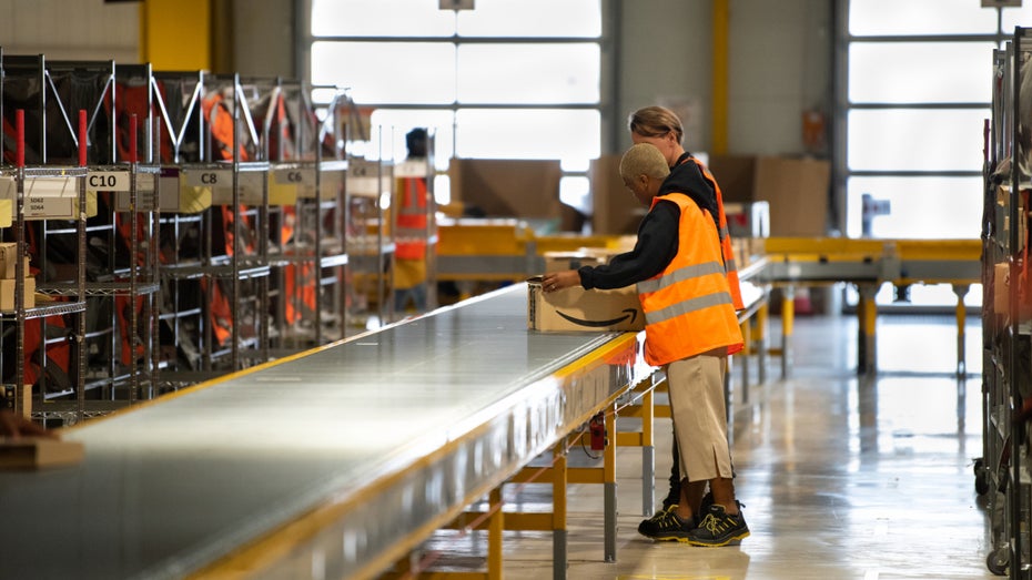 Arbeiter:innen in einem Amazon-Logistikzentrum. (Foto: Frederic Legrand - COMEO / Shutterstock.com) IOSS, Einfuhrabgaben, Marktplatzhaftung – das müssen Händler bei Zoll- und Logistikprozessen beachten