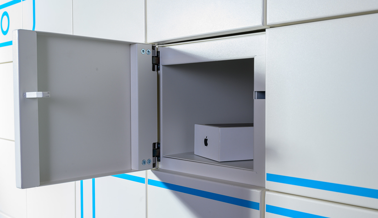 Ein iPhone in einem geöffneten Fach des IT-Automaten CORA