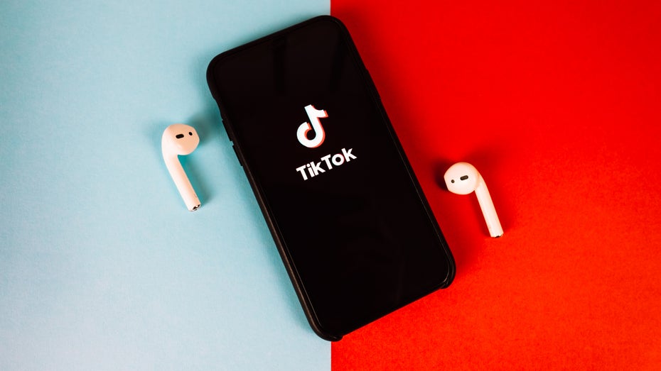 Smartphone mit Tiktok-Logo auf einem zweifarbigen Untergrund