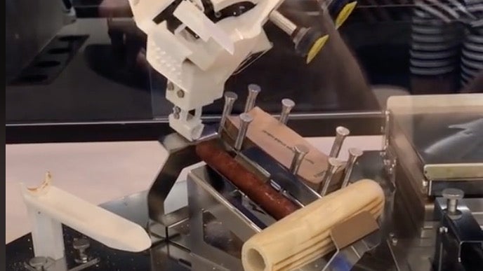 Der Roboter der Hot-Dog-Bude bekommt gleich zwei Mal seine Aufgabe nicht hin. (Screenshot: TikTok/t3n.de) Virales Video: So grandios scheitert ein Roboter beim Hotdog-Zubereiten