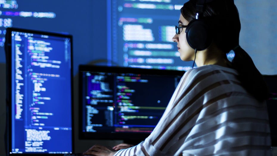Eine Frau sitzt vor mehreren Monitoren (Symbolfoto). IT-Karriere: Was Programmierer können müssen, um begehrt zu bleiben