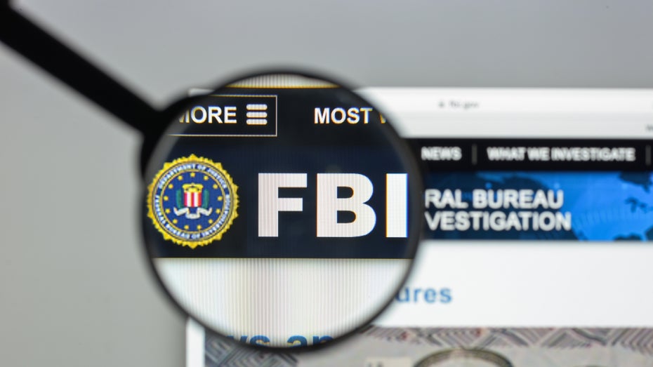Website des FBI, auf der eine Lupe das Logo vergrößert anzeigt. (Bild: Shutterstock/Casimiro PT)
