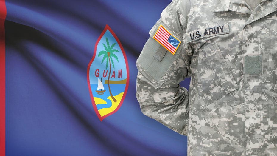 US-Soldat vor einer Flagge der Westpazifikinsel Guam (Bild: Shutterstock / Niyazz)