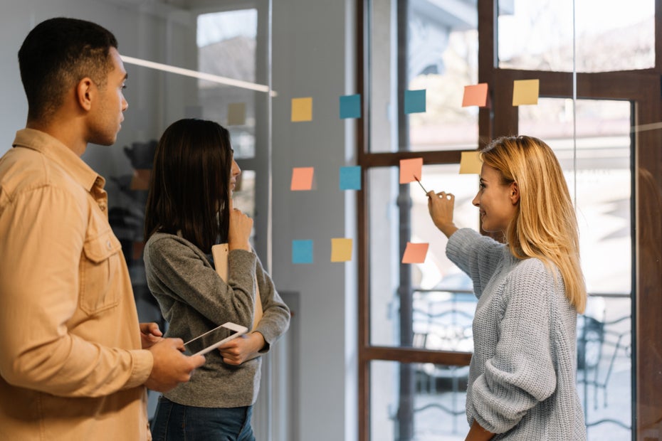 Timeboxing: Menschen beraten über Post-its an einer gläsernen Wand