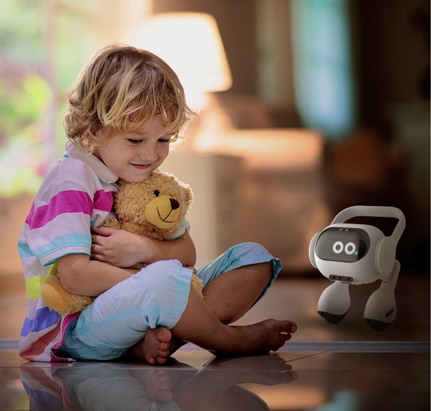 Ein kleines Kind sitzt mit dem Teddy neben dem smarten Roboter von LG.