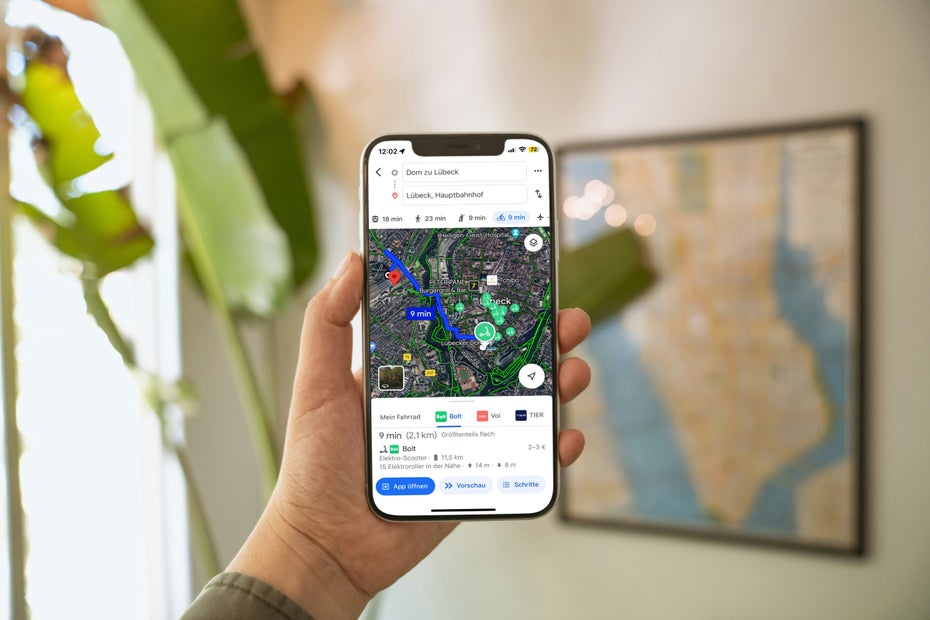 Eine Hand hält ein iPhone mit geöffneter Google-Maps-App.