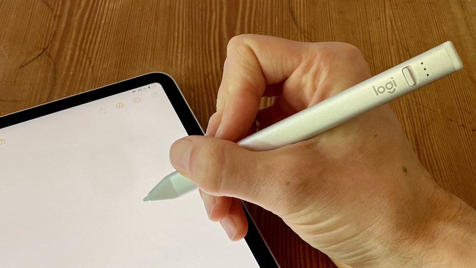 Eine Hand schreibt mit einem Stylus auf einem Tablet.