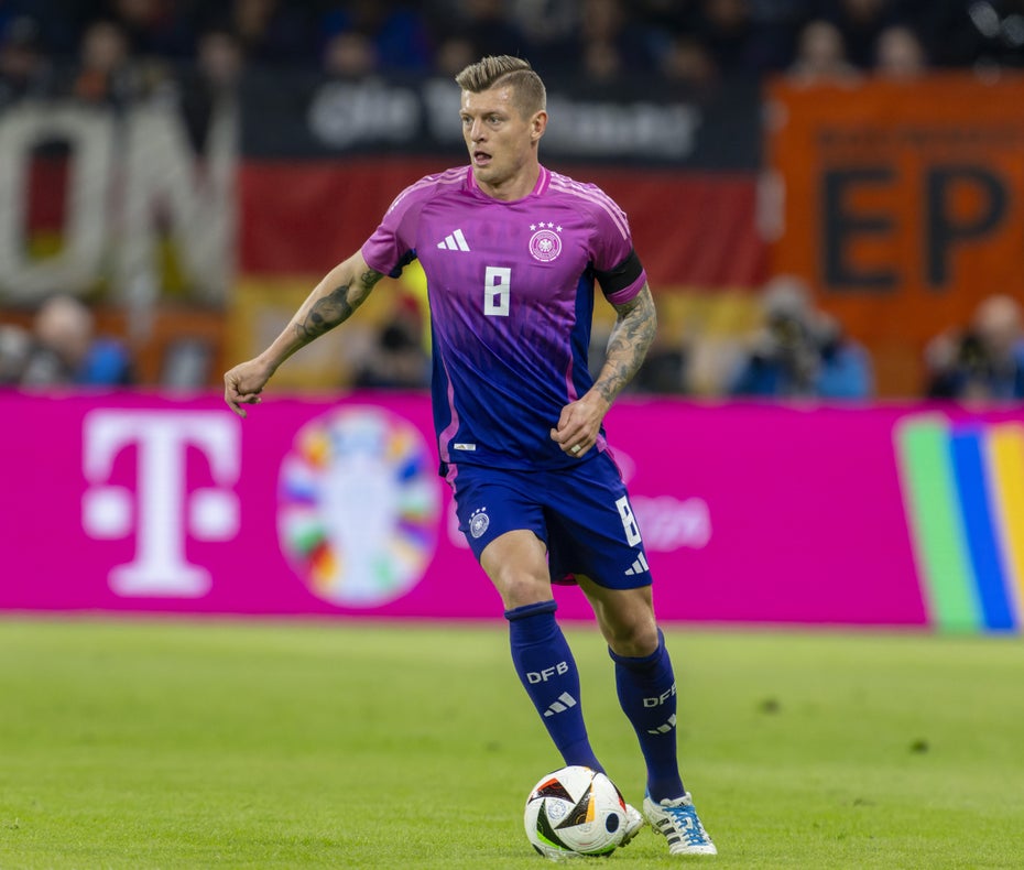 Toni Kroos trägt das Auswärtstrikot und führt den Ball