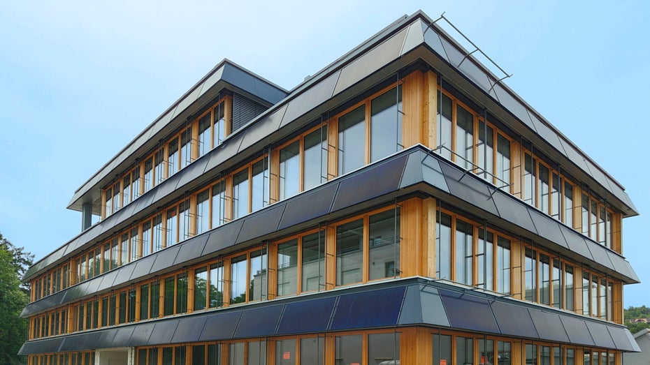 Von Weitem sehen die dunklen Paneele aus wie normale Photovoltaikmodule. Doch die 156 Module mit 309 Quadratmetern liefern nicht nur Strom, sondern auch Wärme für eine Wärmepumpe mit 55 kW Leistung.
(Foto: Consolar Solare Energiesysteme GmbH) Energieversorgung: Wie Solarwärme, Photovoltaik und Wärmepumpen ein Dream-Team sein könnten