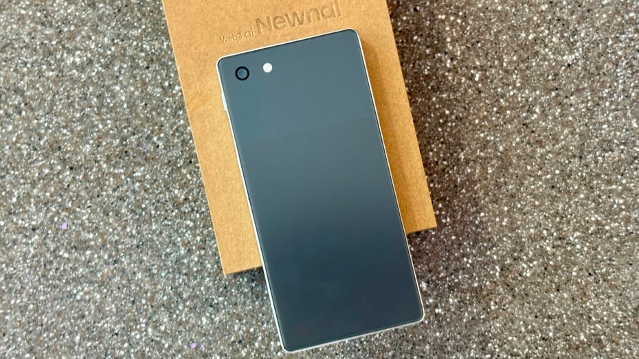 Ein Smartphone liegt auf einem Karton.