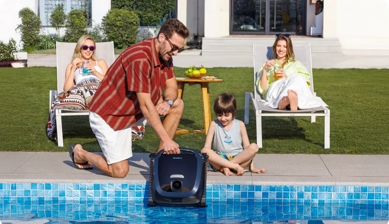 Eine Familie mit Poolroboter im Garten am Pool; es ist sommerlich.